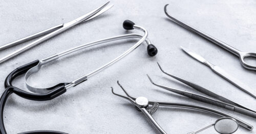 Surgical equipment made from medical-grade stainless steel is next to a stethoscope used for general practice.
